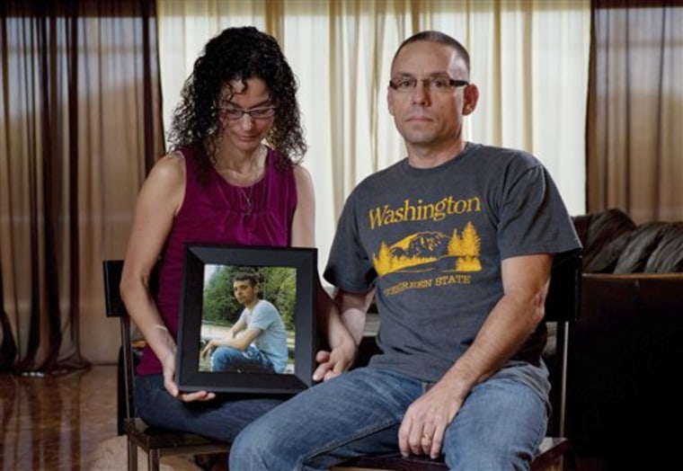 Emma and Christopher Winfield hold a photograph of their son, 22-year-old U.S. Army Spc. Adam Winfield, at their home in Cape Coral, Fla.,  Friday, Sept. 3, 2010. Adam is accused of murdering civilians during his deployment to Afghanistan, a charge he and his family firmly refute.  (AP Photo/Erik Kellar)